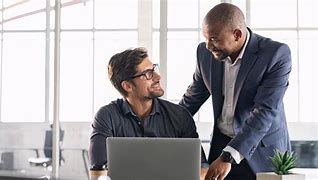 Illustrative stock photo showing a business leader engaging with team members during a meeting, capturing the dynamic nature of modern leadership and workplace collaboration.